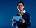 Chinese guy smiling holding an ipad Royalty Free Stock Photo