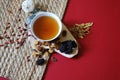 Bowl of chinese herb tea with pieces of astragalus and huang qi roots and jujubes on red background. Top view. Royalty Free Stock Photo