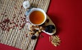 Bowl of chinese herb tea with pieces of astragalus and huang qi roots and jujubes on red background. Top view. Royalty Free Stock Photo