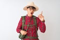 Chinese hiker man wearing backpack canteen glasses hat over isolated white background pointing finger up with successful idea Royalty Free Stock Photo