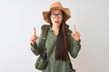 Chinese hiker woman wearing canteen hat glasses backpack over isolated white background amazed and surprised looking up and Royalty Free Stock Photo