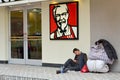 Chinese homeless on sit outside KFC fast food restaurant