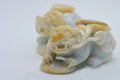 Close-up macro shot of a jadeite Chinese guardian lion or foo fu dog figurine, on white background