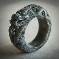Chinese jade ring. Han period. Dark grey jade with blakish clouding, decorated with dragons in relief.