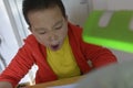 Chinese kid yawn doing homework