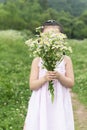 Chinese kid holding white flowers bouquet in hand cover face