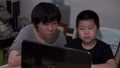 Chinese kid and mother doing online homework amid coronavirus pandemic.