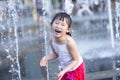 Chinese kid playing with artificial fountain Royalty Free Stock Photo