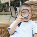 Chinese kid watching through magnifier