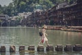 Chinese woman stepping stones in Fenghuang