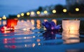 Chinese lanterns floating in river at night with city lights