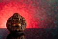 Chinese laughing buddha Hotei or Budai on a red and black gradient background with stars