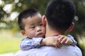 Chinese little boy hugging his father. The boy looks thoughtfully to one side Royalty Free Stock Photo