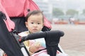 Little daughter in baby carseat with bun in hand Royalty Free Stock Photo