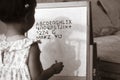 Little daughter writing English letters on white board