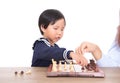 Chinese little girl is learning to play chess under the guidance of teacher
