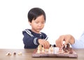 Chinese little girl is learning to play chess under the guidance of teacher