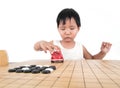 Chinese little girl playing with a car toy on a chessboard with chess pieces