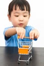 Chinese little girl pushing a toy shopping cart Royalty Free Stock Photo