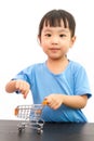 Chinese little girl pushing a toy shopping cart Royalty Free Stock Photo