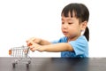 Chinese little girl pushing a toy shopping cart Royalty Free Stock Photo