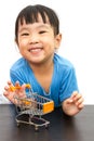 Chinese little girl pushing a toy shopping cart Royalty Free Stock Photo