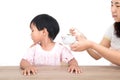 Chinese little girl refuses mother`s feeding in front of white background