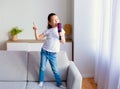 Chinese Little Girl Singing Holding Hairbrush Like Microphone At Home Royalty Free Stock Photo