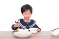 Chinese little girl sitting at the table eating dumplings