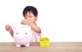 Chinese little girl throws coins into piggy bank Royalty Free Stock Photo