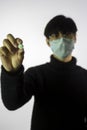 Chinese man in facial mask, focus on pill in hand. Prevent spread of coronavirus Royalty Free Stock Photo