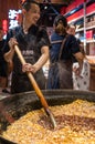 Chinese man mixing food in a huge wok