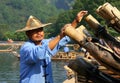 Chinese man preparing bamboo rafts to travel on the River of Nine Bends Royalty Free Stock Photo