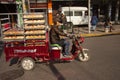 Chinese man riding a cargo moped loaded with bread from a baker in a street in China. Cargo bikes or freight mopeds are popular tr