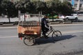 Chinese man riding a cargo tricycle loaded with goods on a roadculture, driving, driver, in China. Cargo bikes or freight tricycl