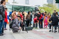 A Chinese man watching his camera and recording a man playing Chinese traditional musical instument Erhu in Shenzhen, China