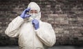 Chinese Man Wearing Hazmat Suit, Goggles and Mask with Brick Wall Background Royalty Free Stock Photo