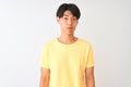 Chinese man wearing yellow casual t-shirt standing over isolated white background depressed and worry for distress, crying angry Royalty Free Stock Photo