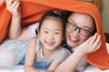 Chinese mom and daughter lay down covered by towel
