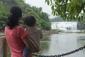 Chinese mom embrace daughter watching waterfall