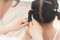 Chinese mom weave plaits for daughter