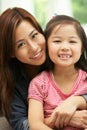 Chinese Mother And Daughter Sitting On Sofa