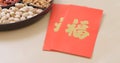 Chinese new year assorted snack tray with red pocket, red poacker with a chinese word meaning luck Royalty Free Stock Photo