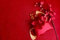 Chinese New Year, blooming plum blossom flower branch with red silk pocket money bag and gold ingot on red background, lucky item