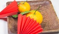 Chinese New Year, composition with mandarins, paper red origami fans on a dark wooden plate on a white background