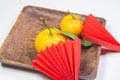 Chinese New Year, composition with mandarins, paper red origami fans on a dark wooden plate on a white background