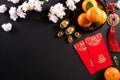 Chinese new year festival decorations pow or red packet, orange and gold ingots or golden lump on a black background. Chinese Royalty Free Stock Photo