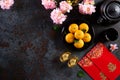 Chinese new year festival decorations pow or red packet, orange and gold ingots or golden lump on a black stone texture background Royalty Free Stock Photo