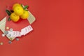 Chinese new year fresh oranges and angpao pocket with wooden board on red paper background Royalty Free Stock Photo