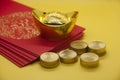Chinese New Year packets with Chinese Gold Ingots and coins on yellow background with customizable space for text